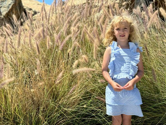 little girl on beach wearing matching light blue skort and tank set