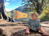 Baby wearing a blue floral bubble onesie outdoors