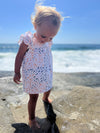 Toddler model enjoying a day at teh beach wearing the Jenn Dress with Blue nad orange school of fish print 