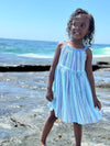 Child model smiling while showing the versatility of her blue striped full skirt sun dress 